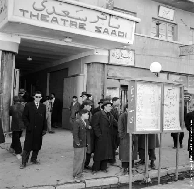 1950: The exterior of Tehrans Theatre Saadi where a group of people study a billboard