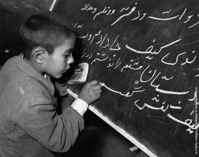 1950: A young Iranian boy learning how to write on a blackboard