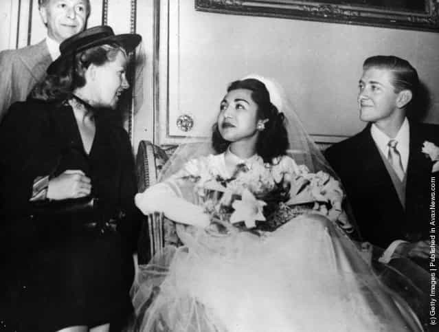 1950: Princess Fatima of Persia and her bridegroom, American University graduate, Vincent Les Hillyer, at their Muslim wedding ceremony at the Persian Embassy in Paris. On the right is American film actress and dancer Rita Hayworth (1918 - 1987), Princess Aly Khan (born Margarita Carmen Cansino)