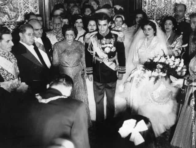 1951: Muhammad Reza Shah Pahlavi (1919 - 1980), the Shah of Iran, at his wedding flanked by his bride and mother
