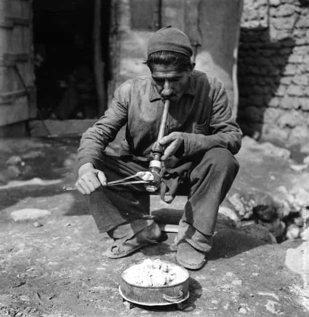 1955: A man smoking opium in a village in Iran