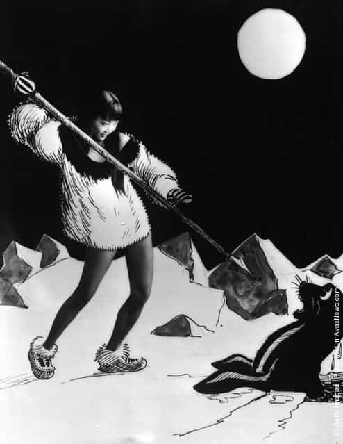1928: American-Chinese actress Anna May Wong aiming a spear at a cartoon sea lion