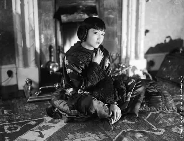 1928: American-Chinese actress Anna May Wong (1907 - 1961) sitting on the floor wearing a wrap
