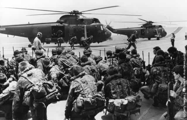 A View of commandos being lifted from the decks of HMS Hermes and HMS Invincible to be transferred by Westland Sea King helicopters to other ships while two aircraft carriers forge ahead to the Falkland Islands from Ascension Island, leaving the marines ready to move at short notice