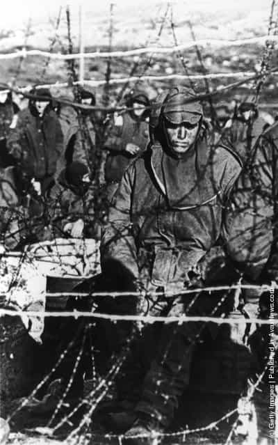 A dejected Argentinian prisoner sits behind barbed wire in a compound on the Falklands Islands during the war with British forces, June 1982. Over 1200 ARgentinians were captured at Goose Green and Darwin