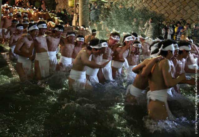 Japanese men wear loincloths as they splash about in freezing cold water during Saidaiji Naked Festival, at Saidaiji Temple