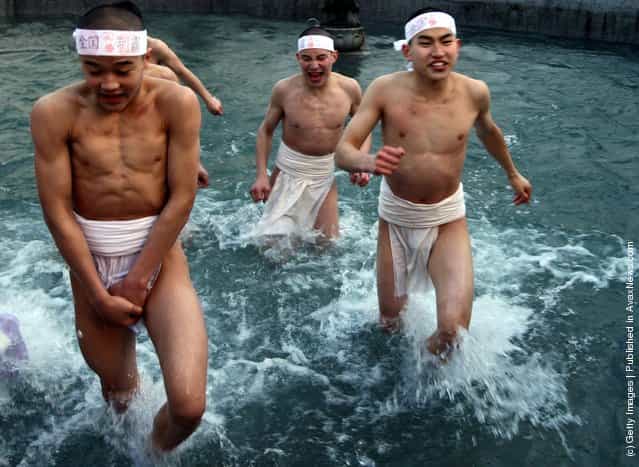Japanese men wear loincloths as they splash about in freezing cold water during Saidaiji Naked Festival, at Saidaiji Temple