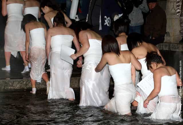Japanese women emerge from freezing cold water during Saidaiji Naked Festival, at Saidaiji Temple