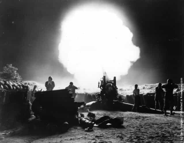 A dramatic shot of 155mm Howitzer fire during night action in the Korean War, 1952