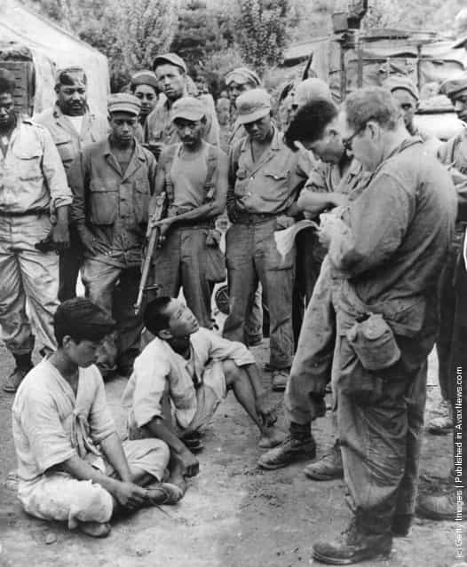 Suspected Communists captured near the lines are brought in for questioning, and later released during the Korean War