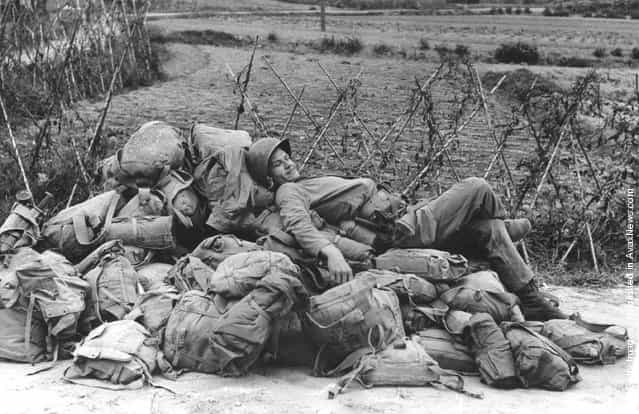 An American soldier relaxing on a heap of kit-bags, shortly after the invasion and capture of the Korean port of Inchon