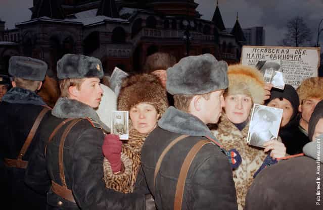Soviet mothers who lost their sons in the Red Army are held back by State militia as they hold photographs of their loved ones in Red Square, on Monday, December 24, 1990. A group of about 200 Soviet parents who have all lost sons through ethnic violence and accidents within the Soviet armed services demonstrated outside the Kremlin. 6,000 Soviet service men were killed during 1990