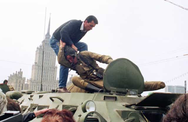 A pro-democracy demonstrator fights with a Soviet soldier on top of a tank parked in front of the Russian Federation building on August 19, 1991, after a coup toppled Soviet President Mikhail Gorbachev. The same day, thousands in Moscow, Leningrad, and other cities answered Russian Republic President Boris Yeltsins call to raise barricades against tanks and troops