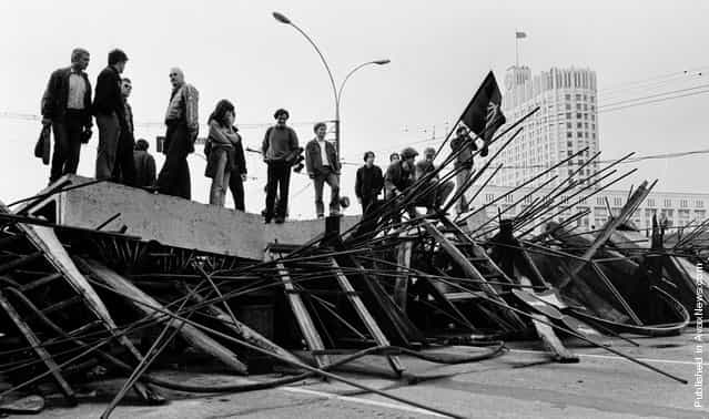 People stand on a barricade in front the Russian White House in Moscow on August 21, 1991