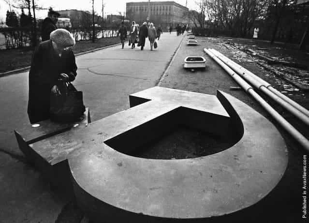 A woman reaches into her bag, which rests on a fallen Soviet hammer-and-sickle on a Moscow street in 1991. December 25, 2011 will mark the 20th anniversary of the fall of the Soviet Union
