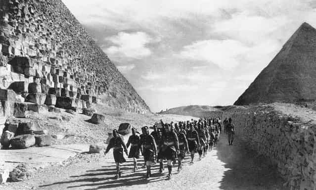 Cameron Highlanders, a Scottish infantry regiment of the British Army, and Indian troops march past the Great Pyramid in the North African Desert, on December 9, 1940
