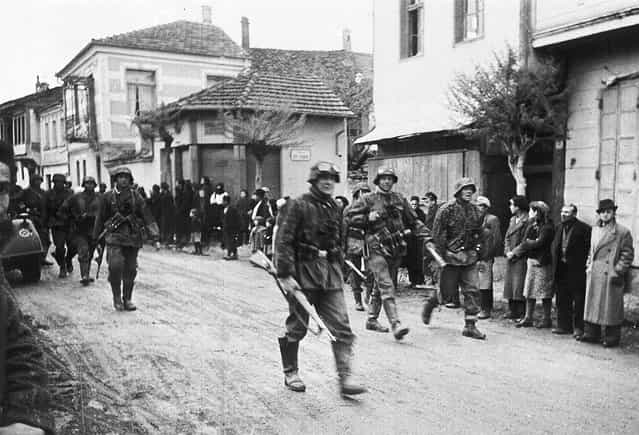 A squad of German soldiers pass through a Greek village, during the occupation of Greece, in May 1941