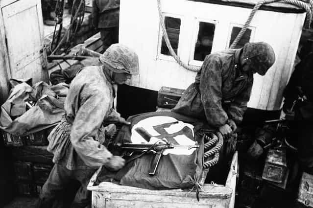 To alert their own airforce to their presence, soldiers spread the Swastika across boats used by the S.S. troops to cross the Gulf of Corinth, Greece, on May 23, 1941