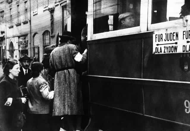 A scene from the Warsaw Ghetto where Jews are seen wearing white armlets bearing the Star of David and trams are seen marked with the words [For Jews Only], on February 17, 1941