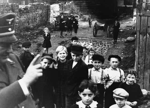 A German Army officer lecturers children in a ghetto in Lublin, German-occupied Poland, on December 1940, telling them [Don't forget to wash every day]