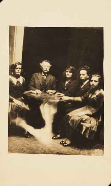 A seance. A photograph of a group gathered at a seance, taken by William Hope (1863-1933) in about 1920
