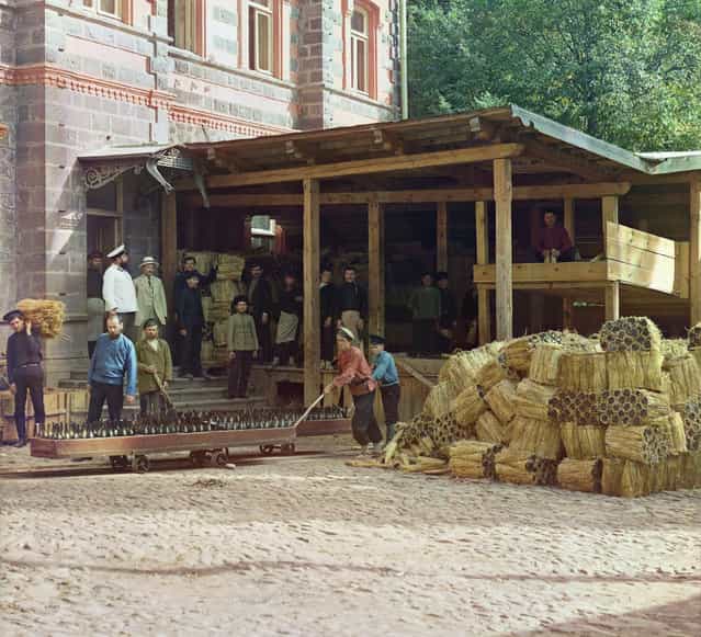 Photos by Sergey Prokudin-Gorsky. Distributing of mineral water. Borzhom (Men pushing carts laden with bottles while others stand and watch; to the side are bundles of packed bottles). Russia, Tiflis province, Gori district, Borjomi, 1912
