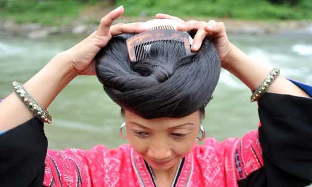 A woman combs her hair at the Huangluo Village of the Yao ethnic group in Guilin, south China's Guangxi Zhuang Autonomous Region, July 15, 2012. (Photo by Lu Boan/Xinhua)
