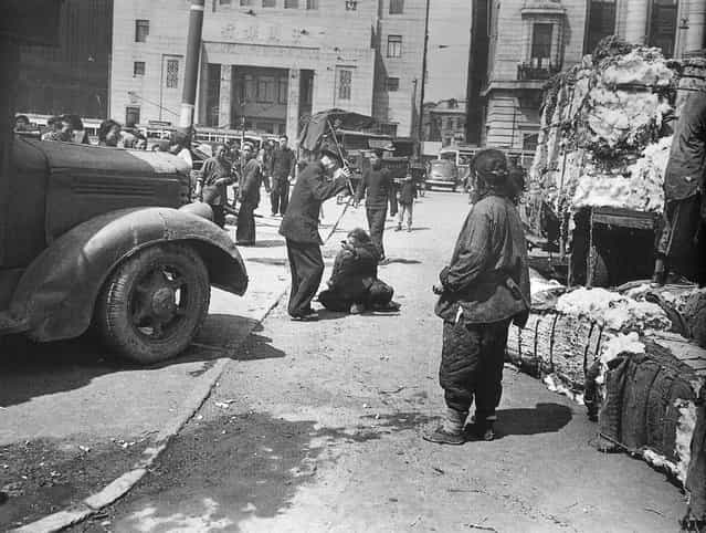 1948年3月，外滩，便衣警察棒打偷拿棉花的老太。 (In March 1948, the Bund, plainclothes police officers wreck stole cotton Granny)