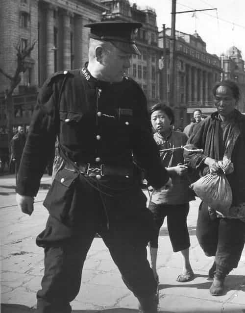 1948年3月，外滩。警察逮捕拿棉花的母女。 (In March 1948, the Bund. Arrested by the police to take the cotton mother and daughter)