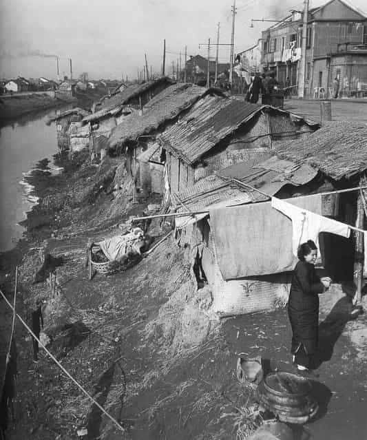 1947年12月，在河边贫民窟凉晒衣服的女人 (In December 1947 the riverside slum woman Liangshai clothes)
