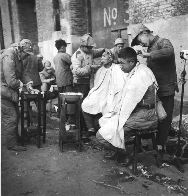 1948年10月， 上海黄浦路，在街边剃头的从东北撤下来的士兵。 (In October 1948, Shanghai Huangpu, soldiers removed from the northeast to shave their heads in the street)
