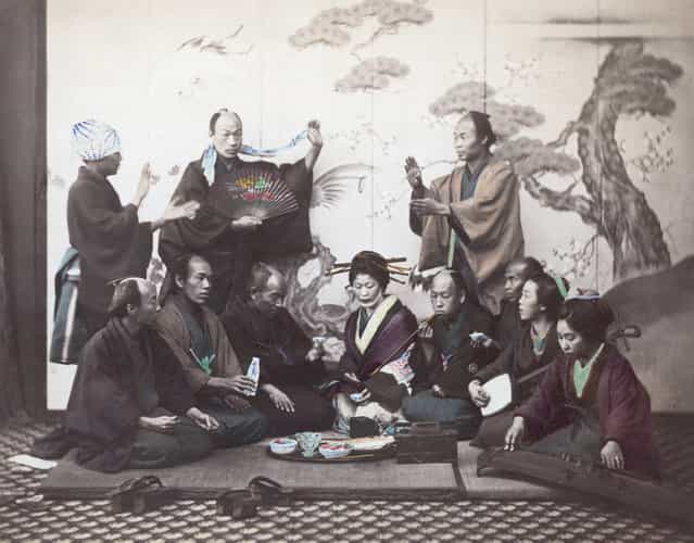 An elegant meal in Japan, circa 1865. The two ladies on the right are playing a shamisen and a koto, while a communal pipe is passed around. (Photo by Felice Beato/Spencer Arnold)