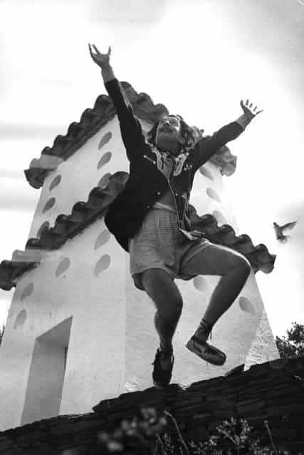 Spanish surrealist artist Salvador Dali (1904–1989) cavorting on a rooftop at his home in Cadaques on the Spanish Costa Brava, 1955. (Photo by Charles Hewitt)