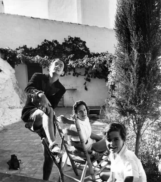 Spanish artist Salvador Dali (1904–1989) with his wife Gala (1894–1982) and a child at his villa at Port Lligat, 1951. (Photo by Daniel Farson)