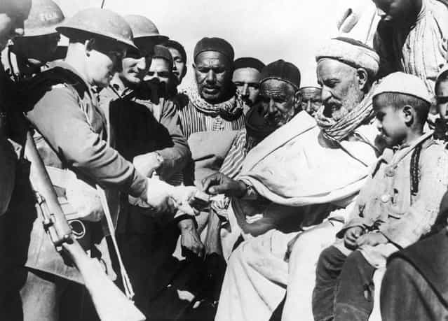 Local people accept gifts from troops during the British occupation of Darnah, Libya during the North African campaign of World War II, 28th February 1941. (Photo by Keystone)
