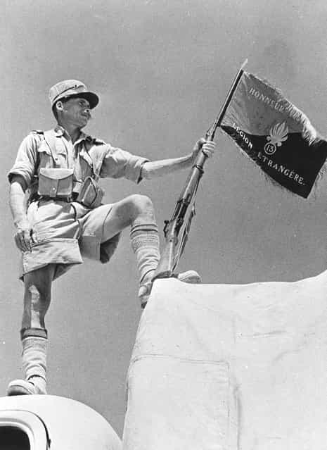 A soldier of the French Foreign Legion holding his regiment's banner at Bar Hacheim in Libya, circa 1940. (Photo by Three Lions)