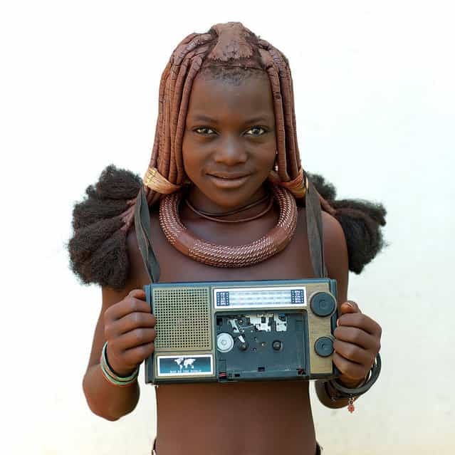 [Himba girl with her radio – Angola. She was walking with her radio around the neck. The tape was broken, but the radio was still working. In the same time, we queue for Ipad, iphod, iphone!]. (Eric Lafforgue)