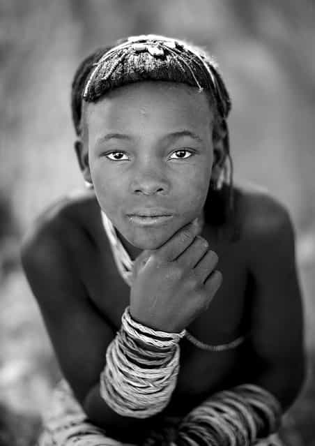 [Mucawana girl – Angola. Muhacaona (Mucawana) tribe girl. The haircut is made with a mix of cow dungs, fat, and herbs for the fragrance. She also wears some bracelets made with ropes]. (Eric Lafforgue)