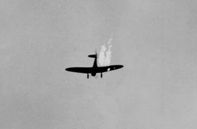 A Japanese dive bomber goes into its last dive as it heads toward the ground in flames after it was hit by Naval anti-aircraft fire during the attack on Pearl Harbor. (Photo by Associated Press)