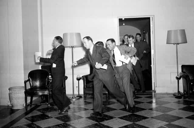 White House reporters dash for telephones after they had been told by presidential press secretary Stephen T. Early that Japanese submarines and planes had just bombed the U.S. Pacific fleet at Pearl Harbor. (Photo by Associated Press)
