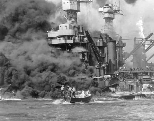 A small boat rescues sailors from the USS 'West Virginia' after she had suffered a hit in the Japanese attack on Pearl Harbor. The USS Tennessee (BB-43) is inboard of the sunken battleship. (Photo by Fox Photos/Getty Images)