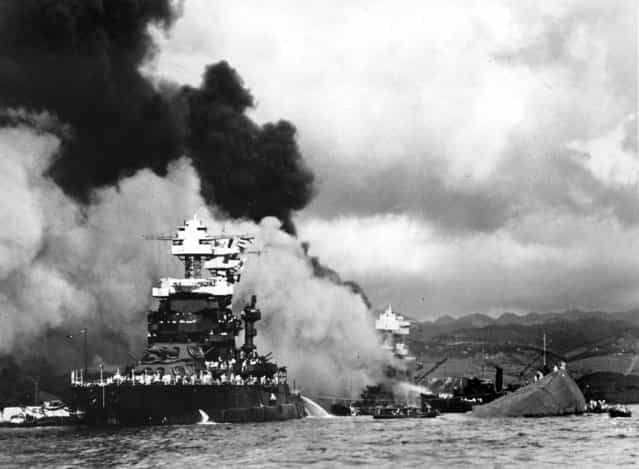 Torpedoed and bombed by the Japanese, the battleship USS West Virginia begins to sink after suffering heavy damage (center) while the USS Maryland (left) is still afloat in Pearl Harbor. The capsized USS Oklahoma is at right. (U.S. Navy/Associated Press)