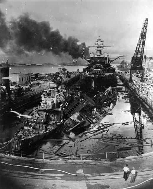 December 1941: The jumbled mass of wreckage in front of the battleship USS Pennsylvania constitutes the remains of the destroyers USS Downes and USS Cassin, bombed by the Japanese during the raid on Pearl Harbour (Pearl Harbor). The ships were in drydock. The torpedo-damaged cruiser USS Helena is in the right distance, beyond the crane. Visible in the centre distance is the capsized USS Oklahoma with USS Maryland alongside. (Photo by Fox Photos/Getty Images)