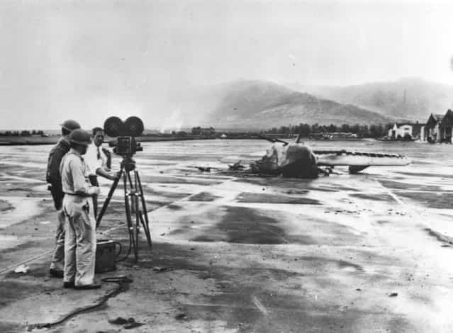 10th December 1941: Wreckage of a US Navy amphibian plane being photographed. It was destroyed during the nearby Pearl Harbour (Pearl Harbor) attack. (Photo by Keystone/Getty Images)