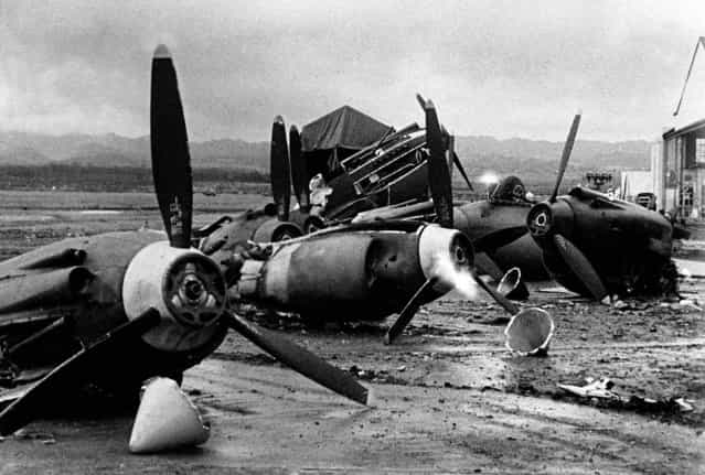 The shattered wreckage of American planes bombed by the Japanese in their attack on Pearl Harbor is strewn on Hickam Field, December 7, 1941. (Photo by Associated Press)
