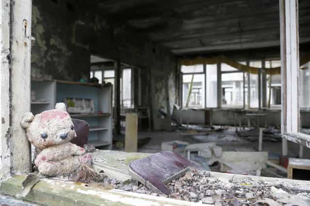 A toy lies in the window frame of a kindergarten in the deserted town of in Pripyat, Ukraine, November 27, 2012, some 3 kilometers (1.86 miles) from the Chernobyl nuclear plant. (Photo by Efrem Lukatsky/AP Photo)