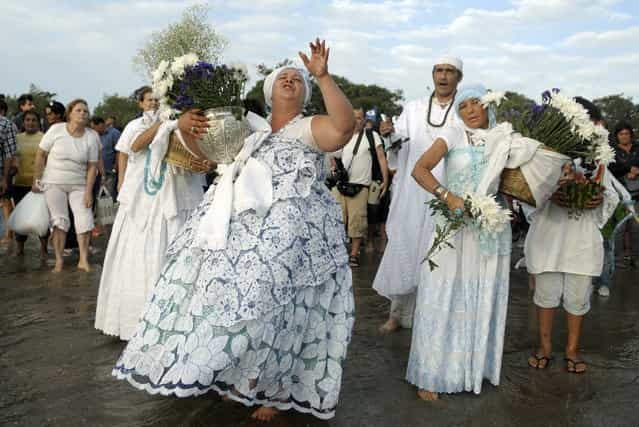 Faithful prepare to wade into the ocean to deliver their offerings to Yemanja, the African sea goddess, during a ceremony honoring the deity in Montevideo, Uruguay, Saturday, February 2, 2013. Thousands of worshippers come to the beach in Montevideo on her feast day, February 2, bearing candles, flowers, perfumes and fruit to show their gratitude for her blessings bestowed upon them. The belief in the goddess sprouts from Umbanda, a blend of religions that include African, Catholicism and Spiritism. (AP Photo/Matilde Campodonico)
