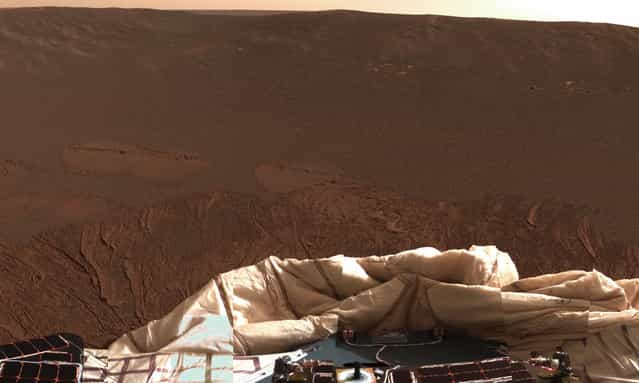 The interior of a crater surrounding the Mars Exploration Rover Opportunity at Meridiani Planum on Mars can be seen in this color image from the rover's panoramic camera, on January 24, 2004. Note the disturbances in the soil from the airbags, which were used to cushion the landing. The airbags are now deflated, seen at bottom. (Photo by NASA/JPL/Cornell/The Atlantic)