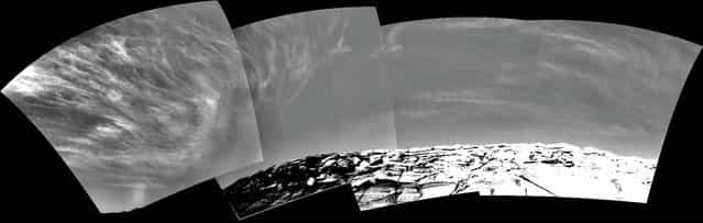 Clouds appear in the Martian sky above Endurance Crater in this mosaic of frames taken by the navigation camera on NASA's Rover Opportunity at about 9:30 a.m. on the rover's 290th sol (November 16, 2004). These clouds are part of a band that forms near the equator when Mars is near the part of its orbit that is farthest from the Sun. (Photo by AP Photo/NASA/JPL/The Atlantic)
