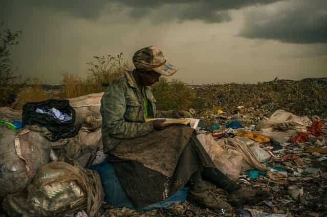 This picture by US photographer Micah Albert, freelance documentary photographer represented by Redux Pictures photo agency is the 1st Prize Contemporary Issues Single in the 56th World Press Photo Contest, it was announced by the organizers on 15 February 2013 in Amsterdam, The Netherlands. Pausing in the rain, a woman working as a trash picker at the 30-acre dump, which literally spills into households of one million people living in nearby slums, wishes she had more time to look at the books she comes across. She even likes the industrial parts catalogs. [It gives me something else to do in the day besides picking trash], she said. This is picture is dated 03 April 2012 in Nairobi, Kenya. (Photo by Micah Albert/EPA)